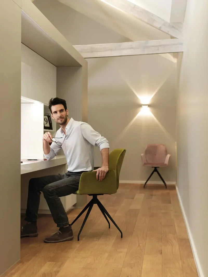 Mobitec Drehsessel in olivgrünem und altrosa Samt mit schwarzem Sterngestell in einem hellen Dachraum mit Holzdielen.